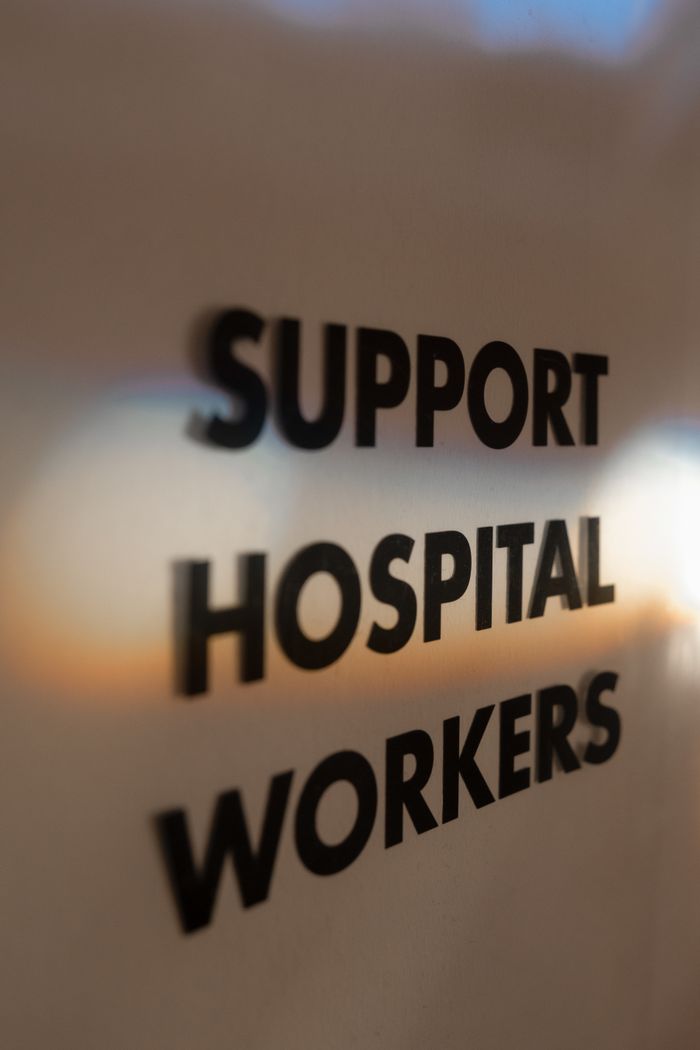 Close-up of 'Support Hospital Workers' text on a blurred background, emphasizing appreciation.